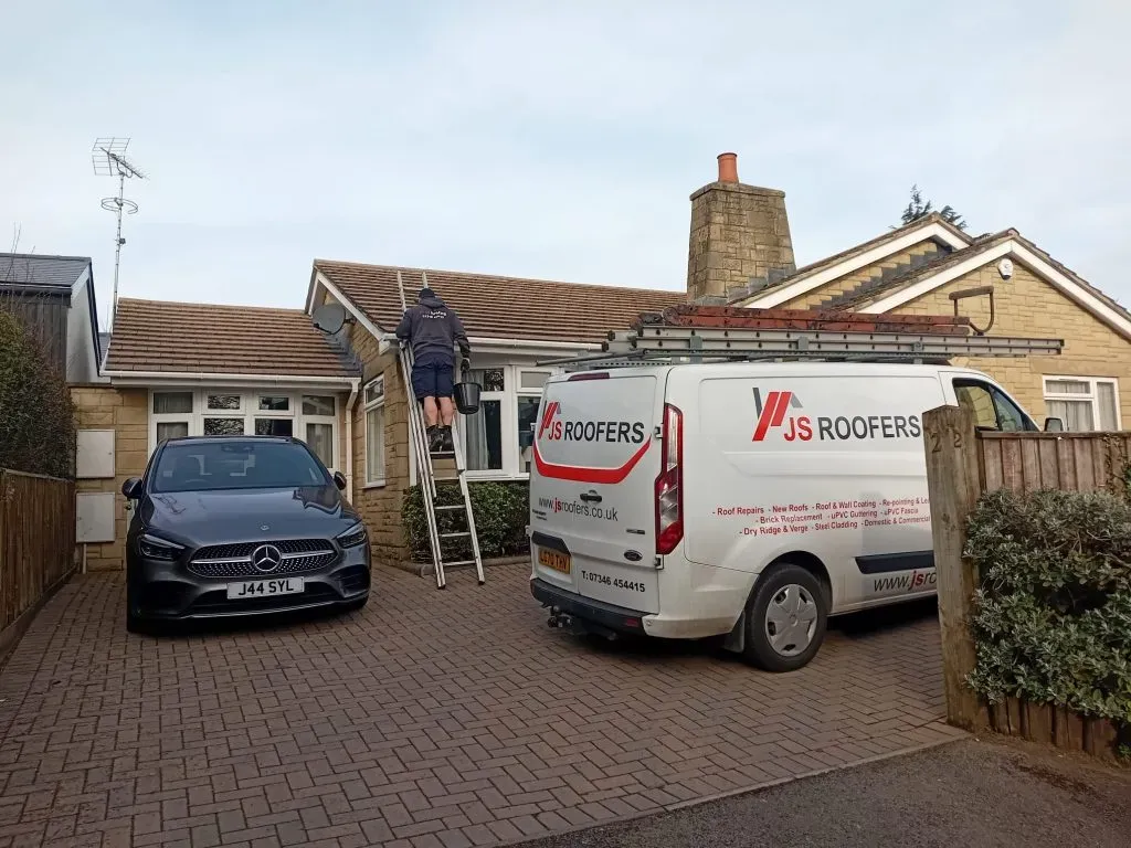 JS Roofers van and ladder on a residential repair job in Cheltenham