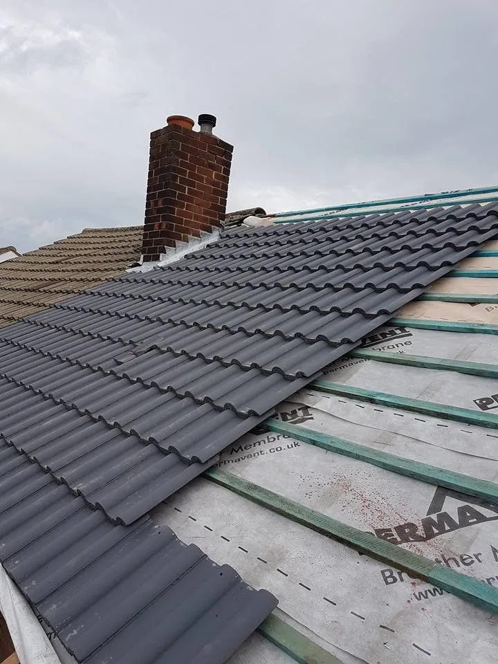 Roofer replacing broken tiles on a Gloucester terraced house